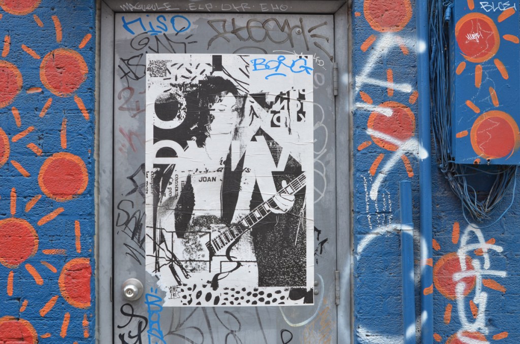 paper pasteup graffiti by Madame Gilles, black and white image of a female guitar player, Joan,