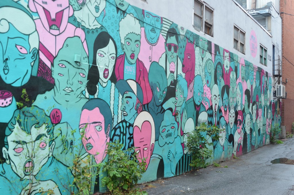mural by Maxilie Martel in an alley in Montreal, faces in pinks and blues, 
