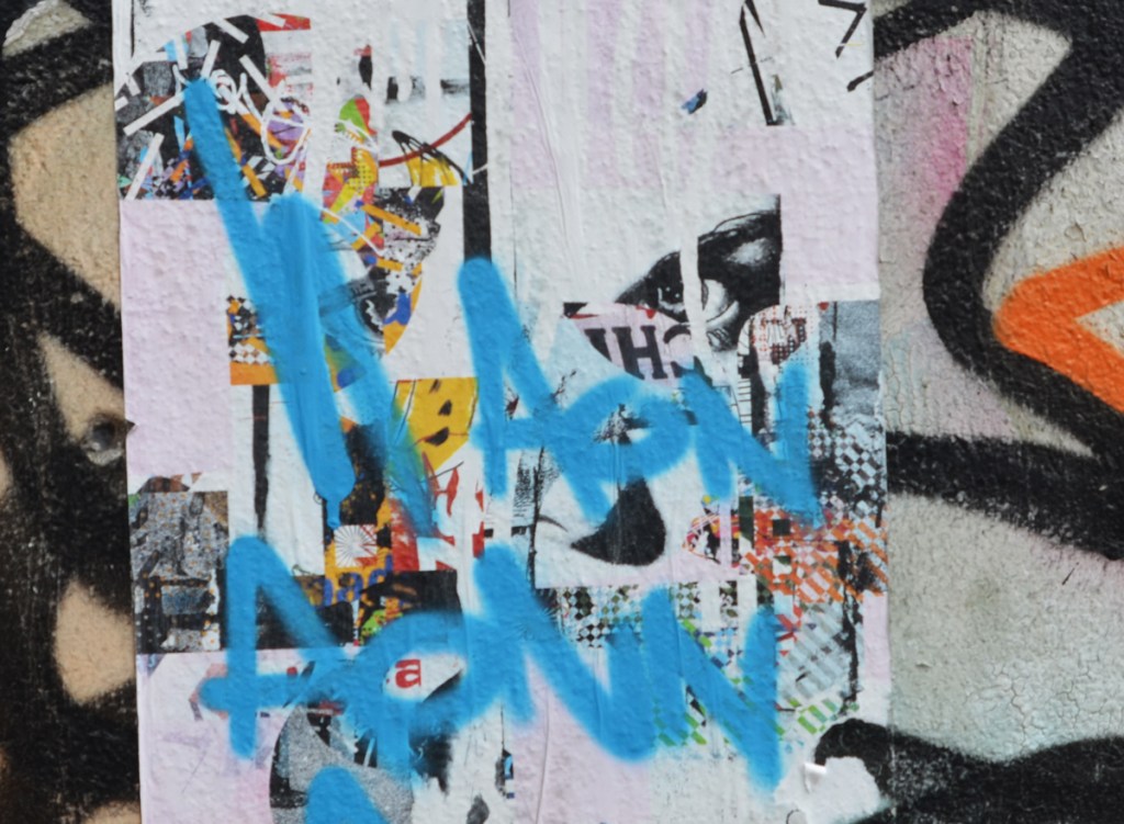 pasteup that was a collage but has been tagged over in blue paint