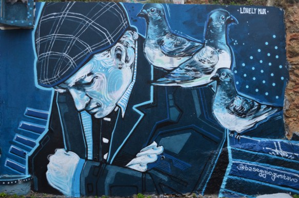 mural street art in blues of an older man in a cap, title Lonely Man, painted by Gustavo Baseggio,