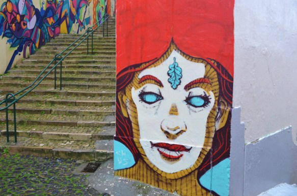 street art mural on a wall of a young man with a leaf painted on his forehead