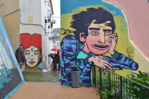 murals, street art, on an outdoor set of stairs, in the rain, people with umbrellas