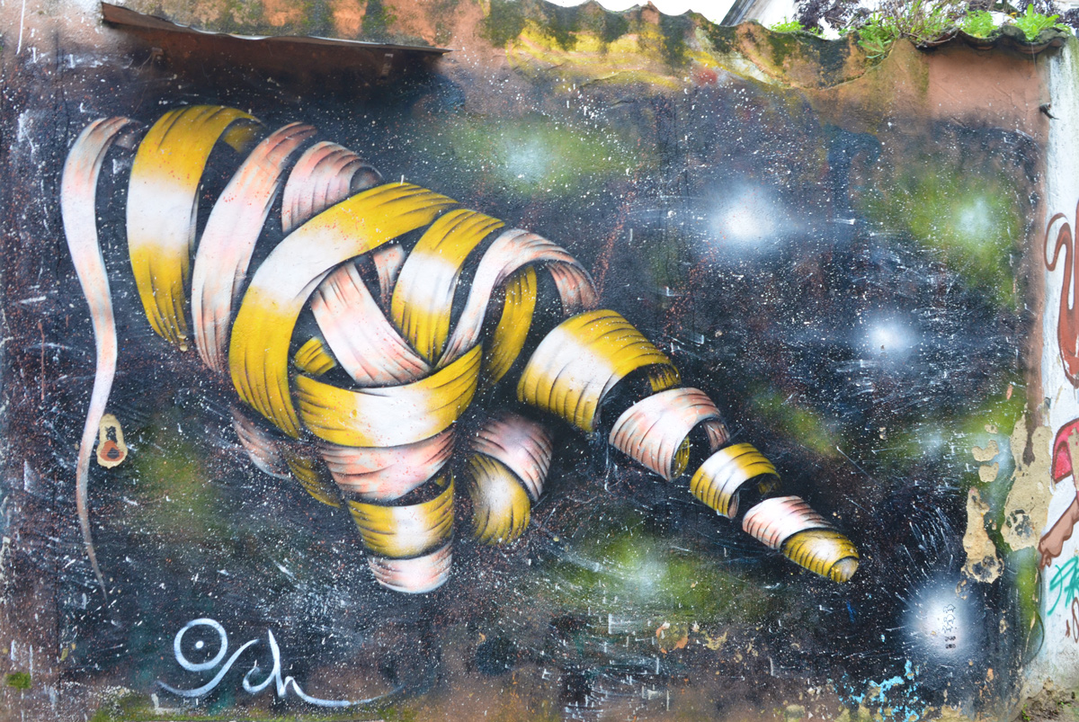 mural by Otto Schade in Lisbon of a hand with finger pointing made of ribbons wrapped around and around