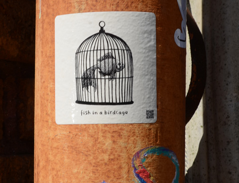 small sticker on a post, white background, black drawing of a fish in a birdcage