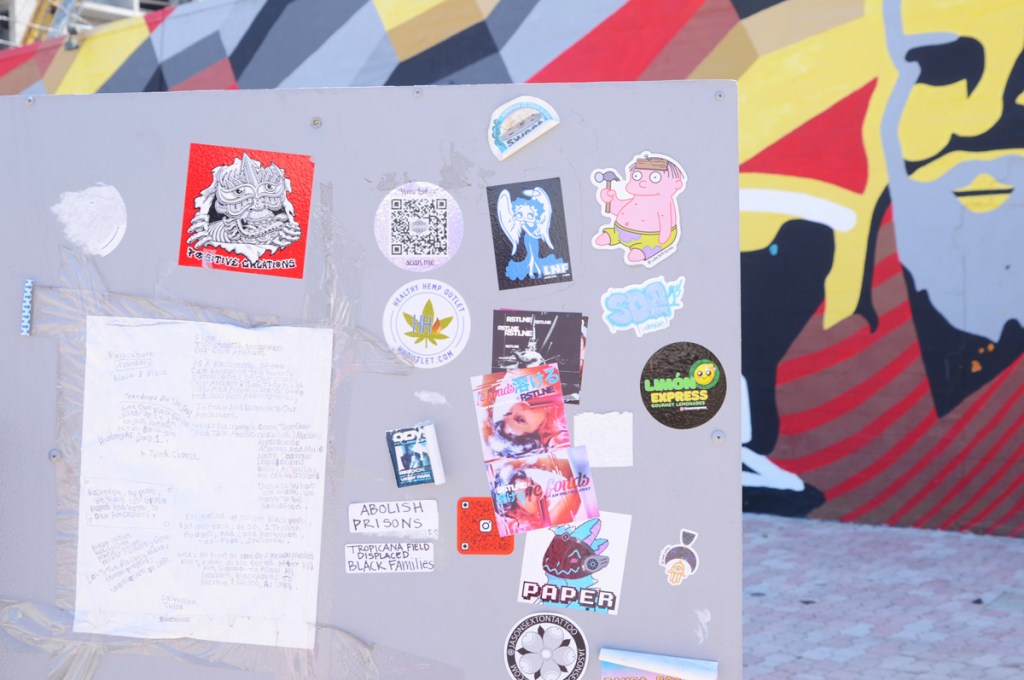 stickers on the back of a street sign