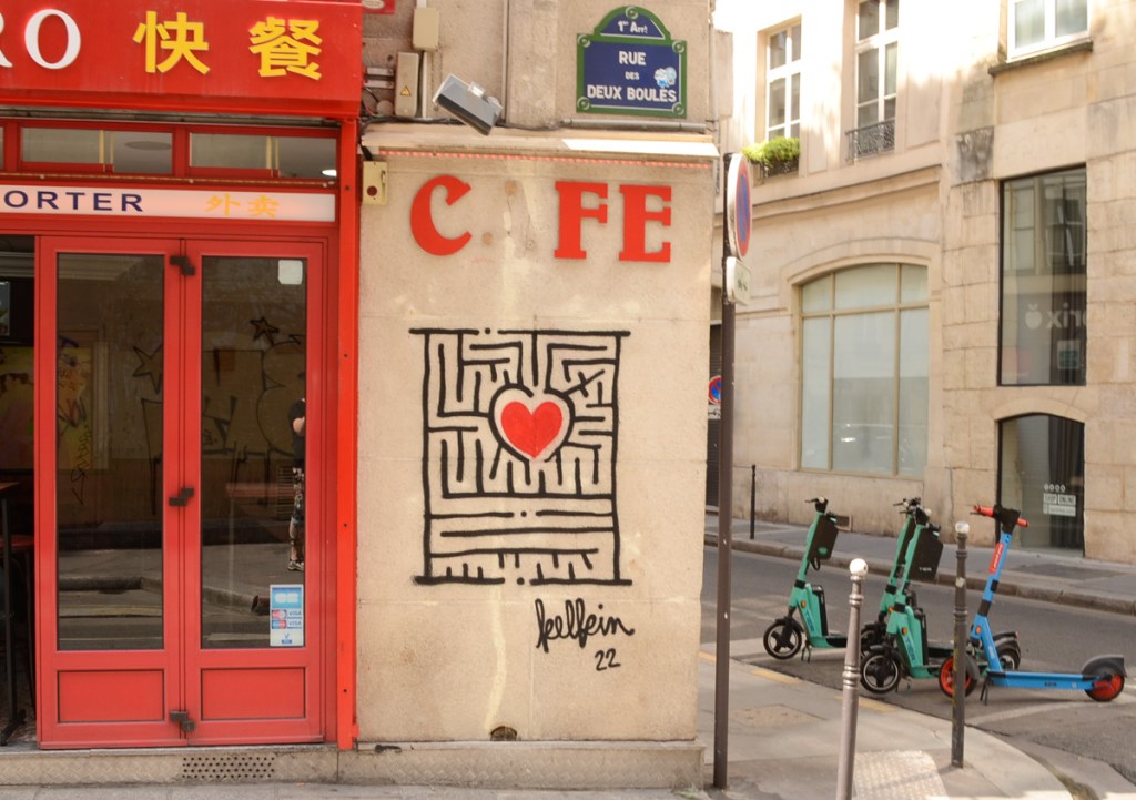 cafe and chinese restaurant on rue des deux boules, with street art painting beside it, a red heart inside a black and white maze