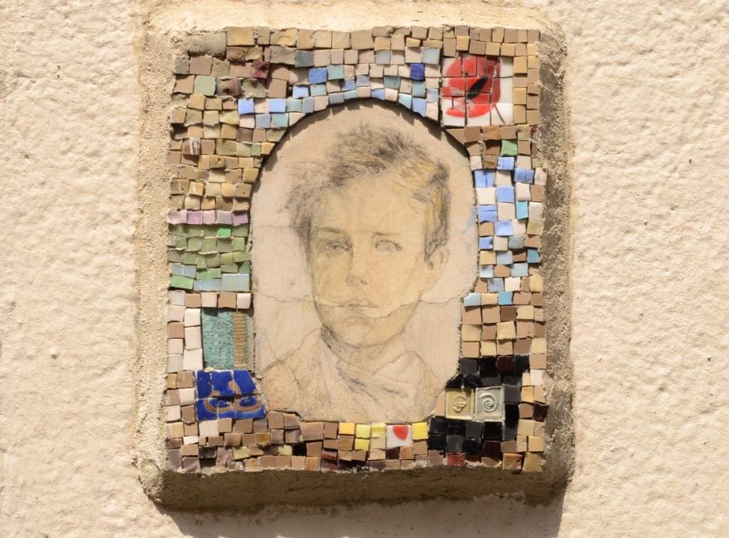 small hand drawn portrait of a young man surrounded by a frame made of many small tiles in different colours