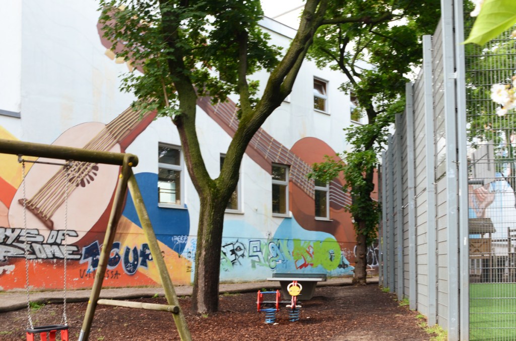 mural in Ernst Lichtblau Park in Vienna, guitar and mandolin, with playground equipment in front of it