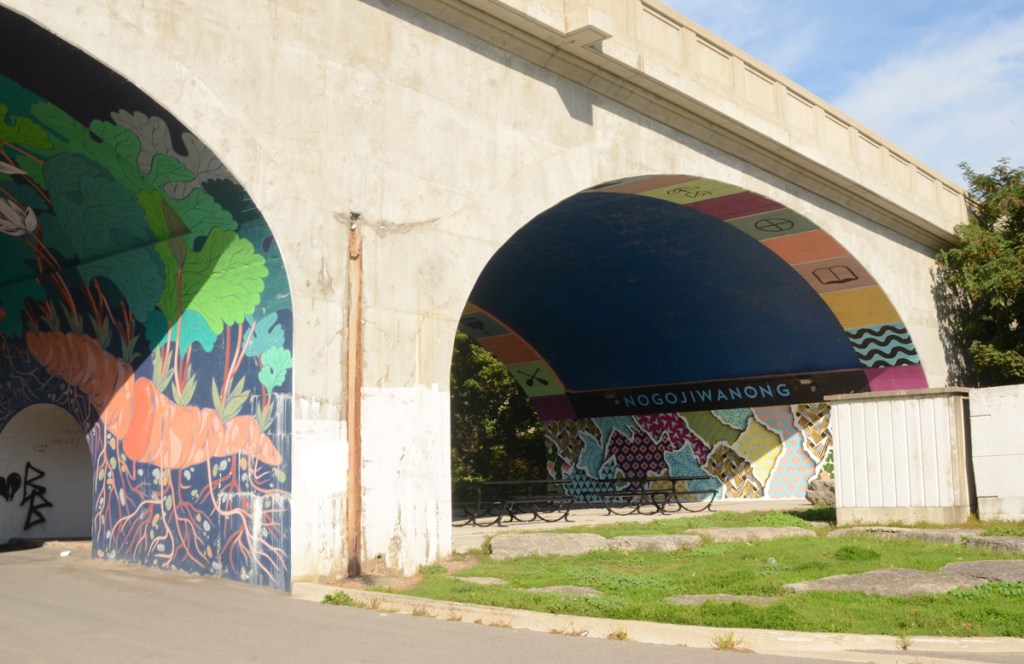 Hunter Street bridge fromJames Stevenson park, grass in front, picnic tables under the arches