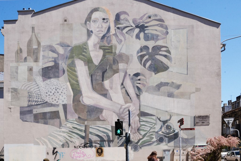 mural by Morik of a woman sitting on the floor beside a telephone, with large plant leaves around her, monstera deliciosa. 