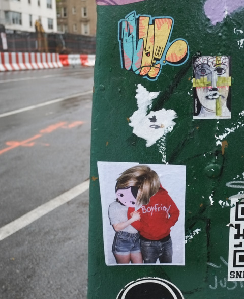 a phoebe of new york sticker, leaning her head onto boyfriends shoulder.  Male in image is wearing a sweatshirt that has boyfriend written on it