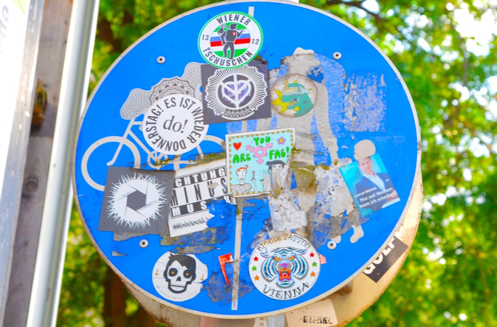 a blue circular street sign that has been covered with stickers
