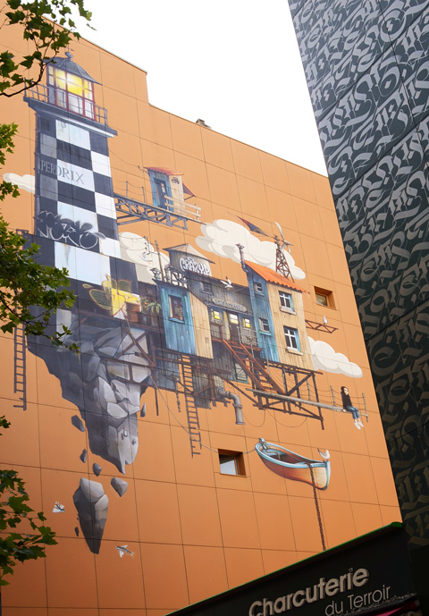 mural painted by wen 2 and paxone on the outside of a multistorey residential building, features a large black and white lighthouse, a jetty, wood buildings on the dock, a girl sitting on the dock, a small boat in the water, a water tower structure with crazy p written on it