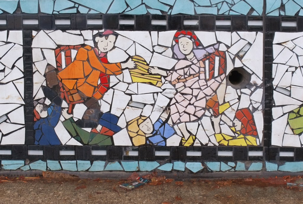 scene from a Jewish wedding, bride and groom held up in the air on chairs 