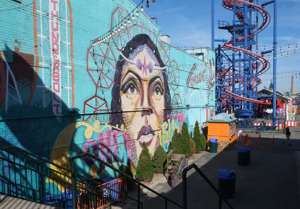 large painting of a woman's face on the side of the cyclone, a roller coaster ride at Luna, the amusement park at Coney Island 