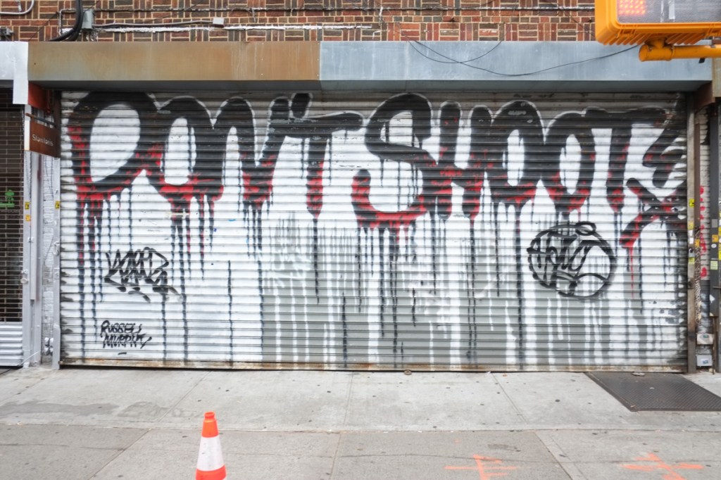 garage door with graffiti, large letters, text that says don't shoot
