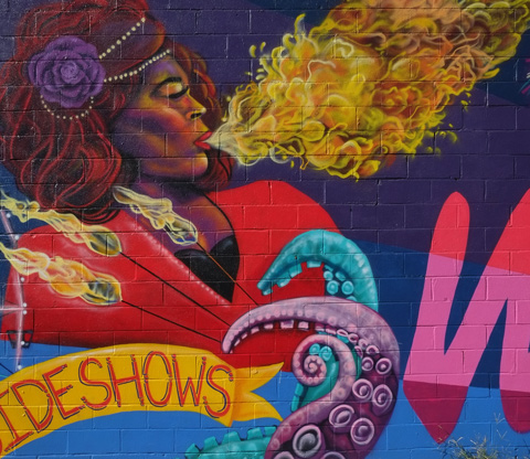 a woman breathing fire in a mural