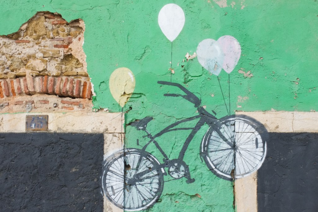 four images on a wall, one is a wheatpaste bicycle