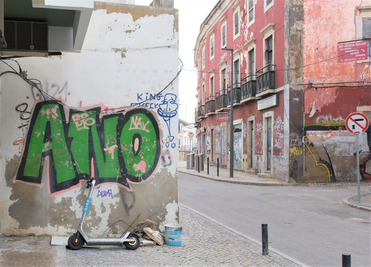 street scene in Faro, green tag saying ano, other buildings in the background