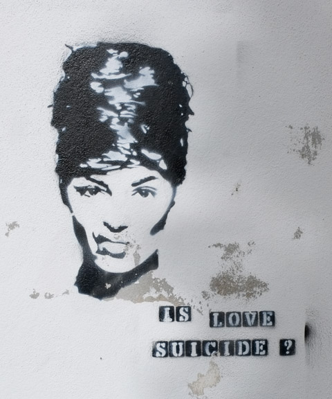 graffiti, image of person with up-do hair style, with words is love suicide?
