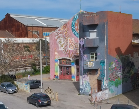 view of front of A D A O building in Barreiro, covered with murals