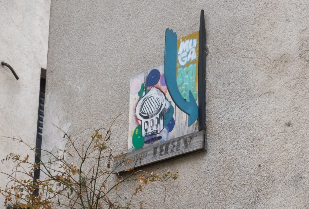 graffiti on a wall, including a blue arrow that sticks out from the wall