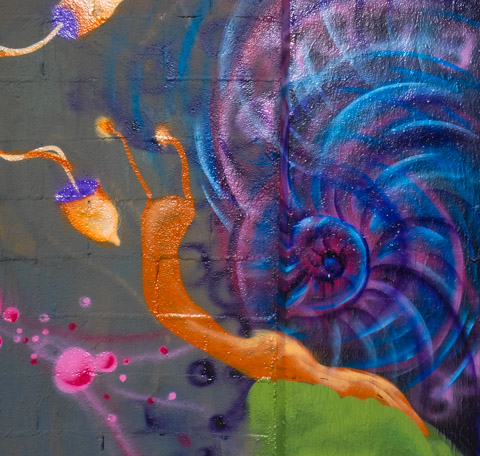 street art mural, urban art, of a snail with purple and blue shell and orange body