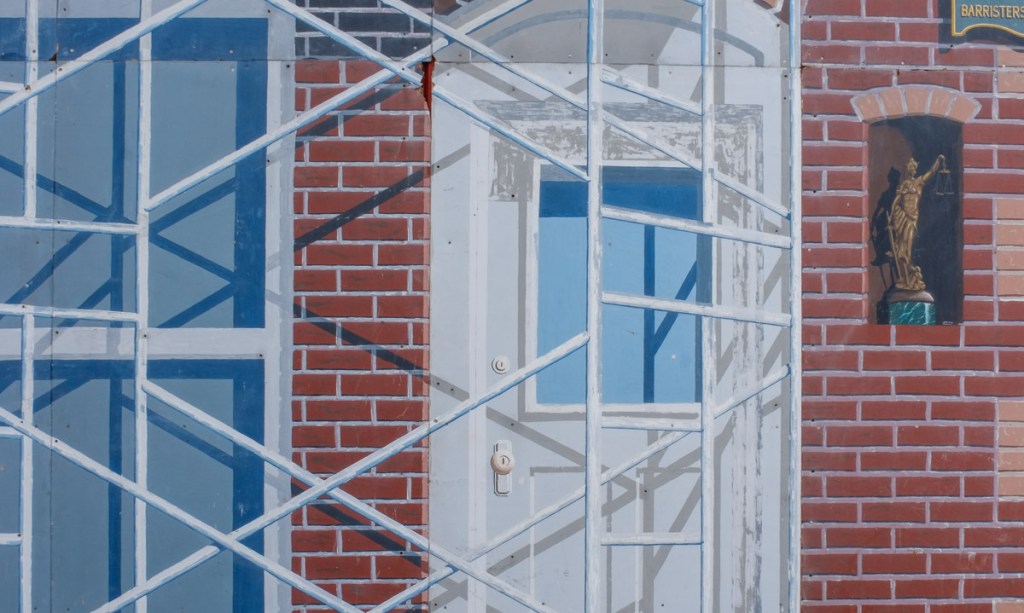 close up of mural, front door with scaffolding beside it