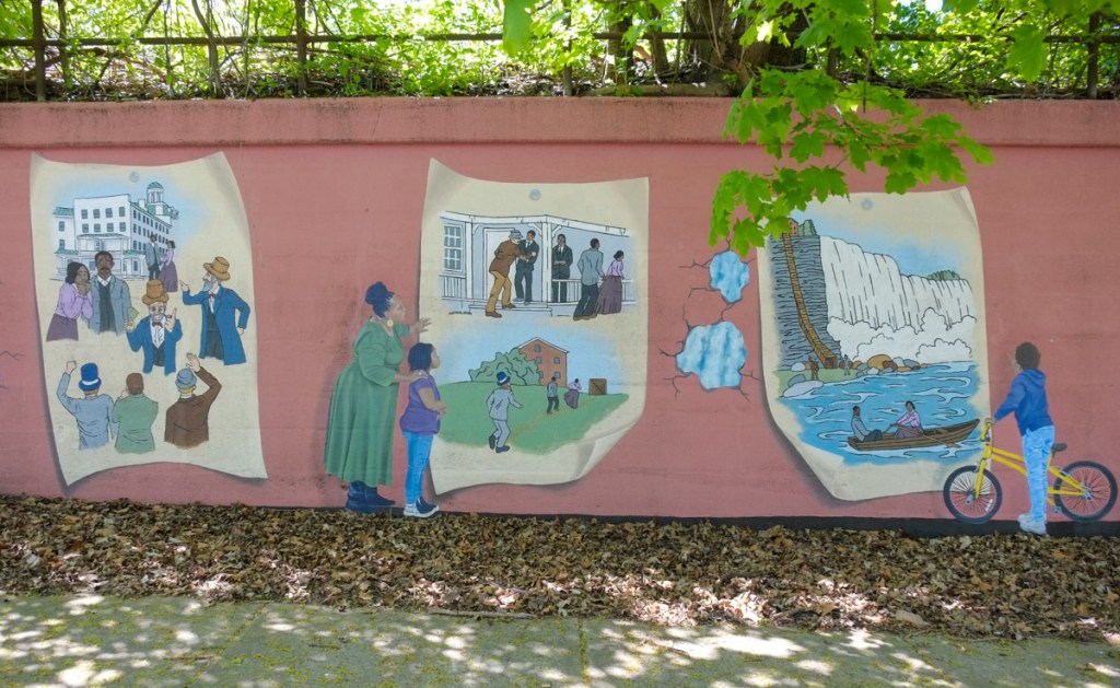 a mural about black history and the underground railroad in Niagara Falls in three scenes