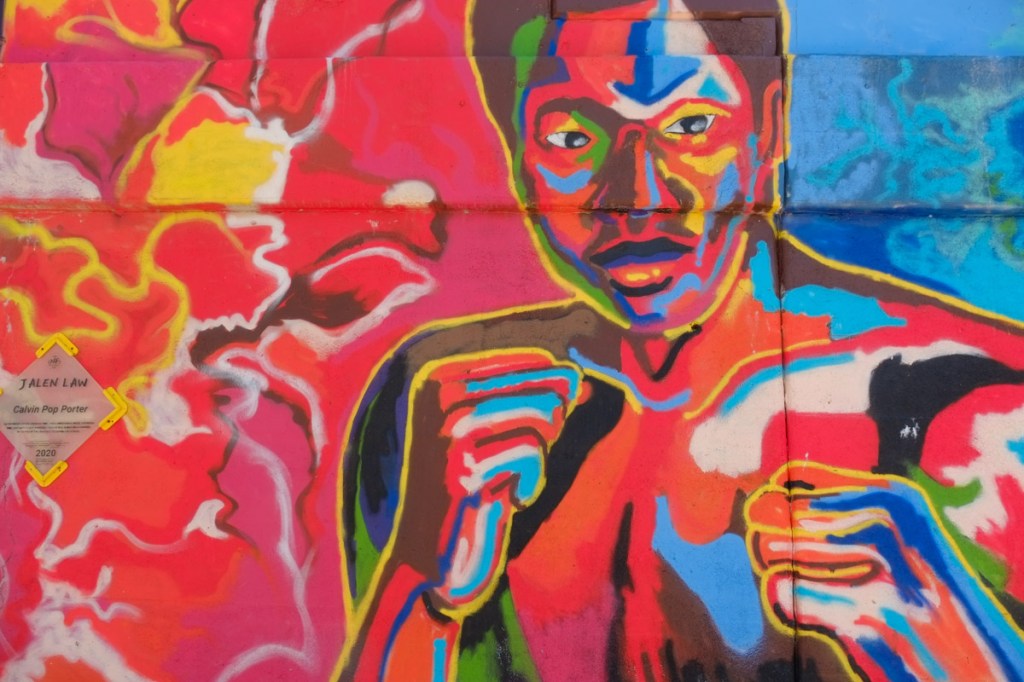 mural by Jalen Law of a boxer, in abstract colours, bright reds and blues
