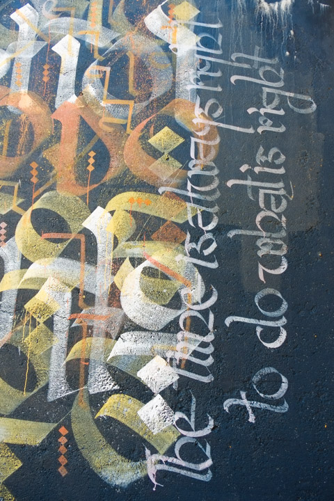 calligraphy and text in a mural that says the time is always right to do the right thing
