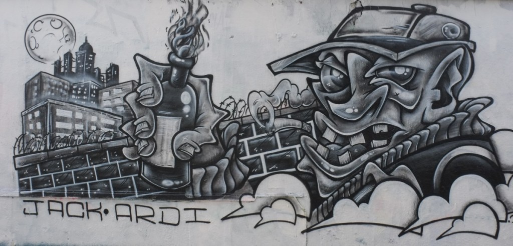 mural of a man holding a molotov cocktail, a glass jar filled with gasoline and topped with a rag that is set on fire, and acts like a small bomb, or to start fires