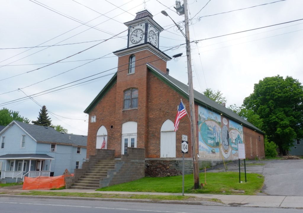 small brick building, with a clock tower, town hall in mexico new york