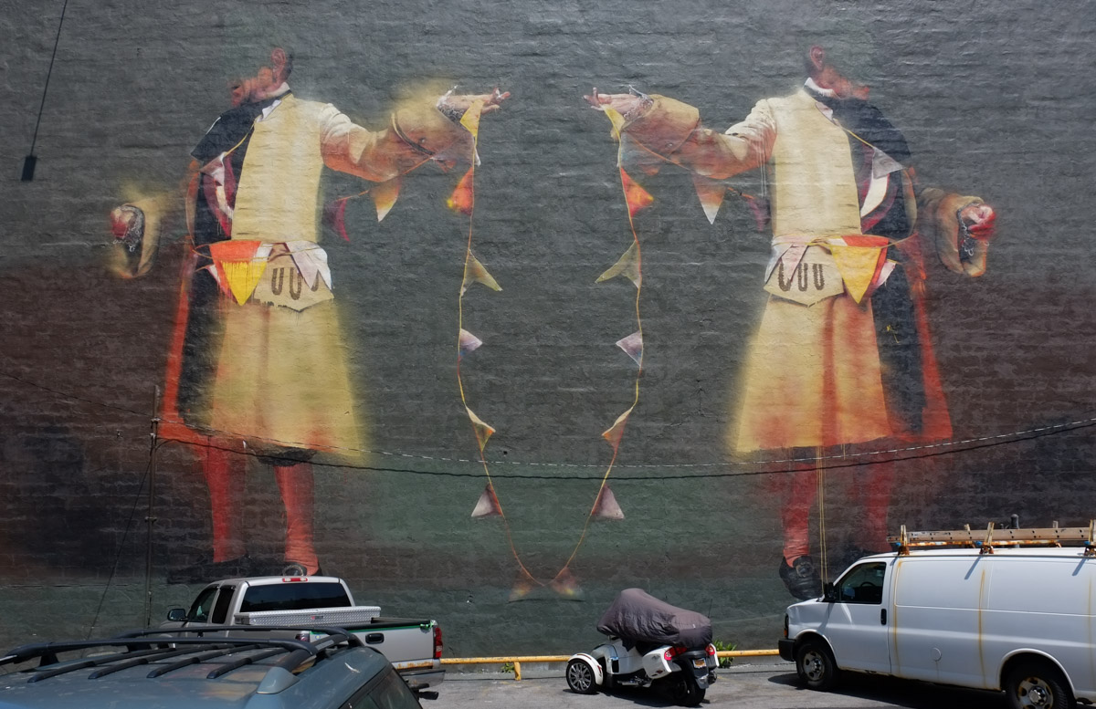 large mural by Conor Harrington in Rochester, a man and his reflection, or possibly two men, 