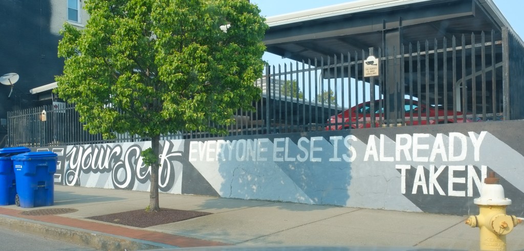 text mural that says be yourself, everyone else is taken