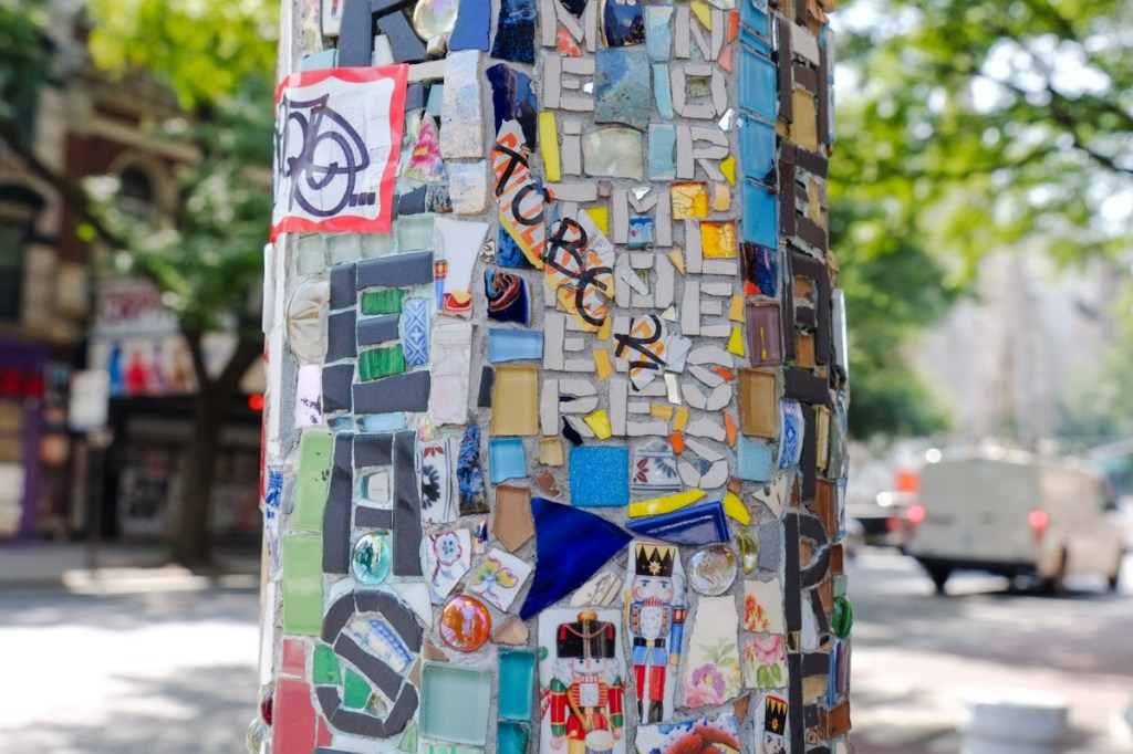 mosaics on outdoor street lamp posts, East Village mosaic trail, some pieces are made into letters that spell words on the poles