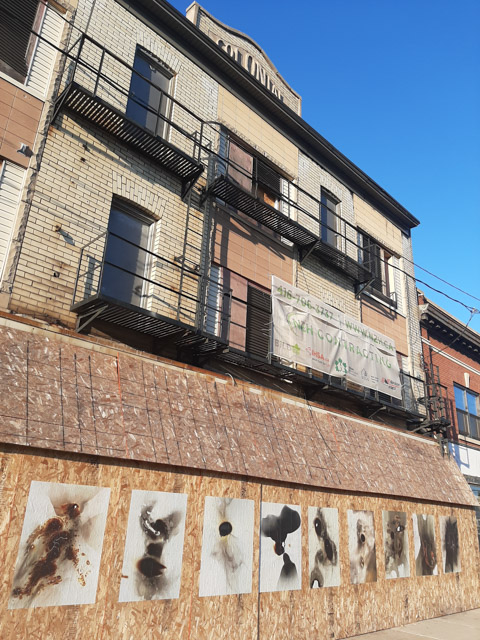 exterior of old abandoned Colonial building in hamilton, with wheat paste street art images on it by_danielle_goshay