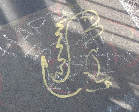 graffiti on pavement, line drawing in yellow of a dinosaur, on hind feet, open mouth, 