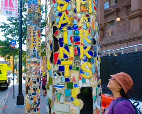 mosaics on outdoor street lamp posts, East Village mosaic trail, yellow pieces make letter to spell St. Marks