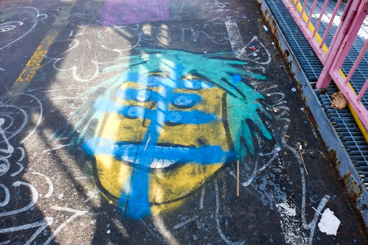 blog_sold_out_artshow graffiti on sidewalk, turquoise hair, yellow face, blue eyes, 3 pairs of eyes
