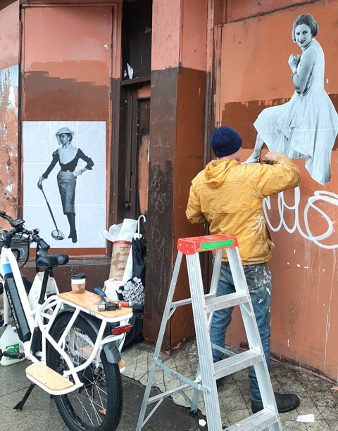 installing wheat paste posters on outside walls