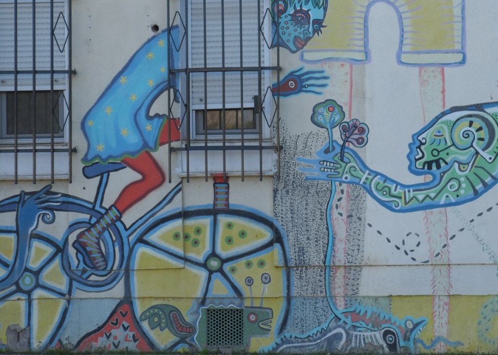 part of a mural, a cyclist on a blue bike