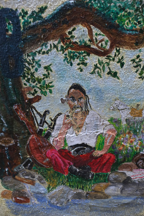 a painting of a person wearing long red pants sitting under a tree