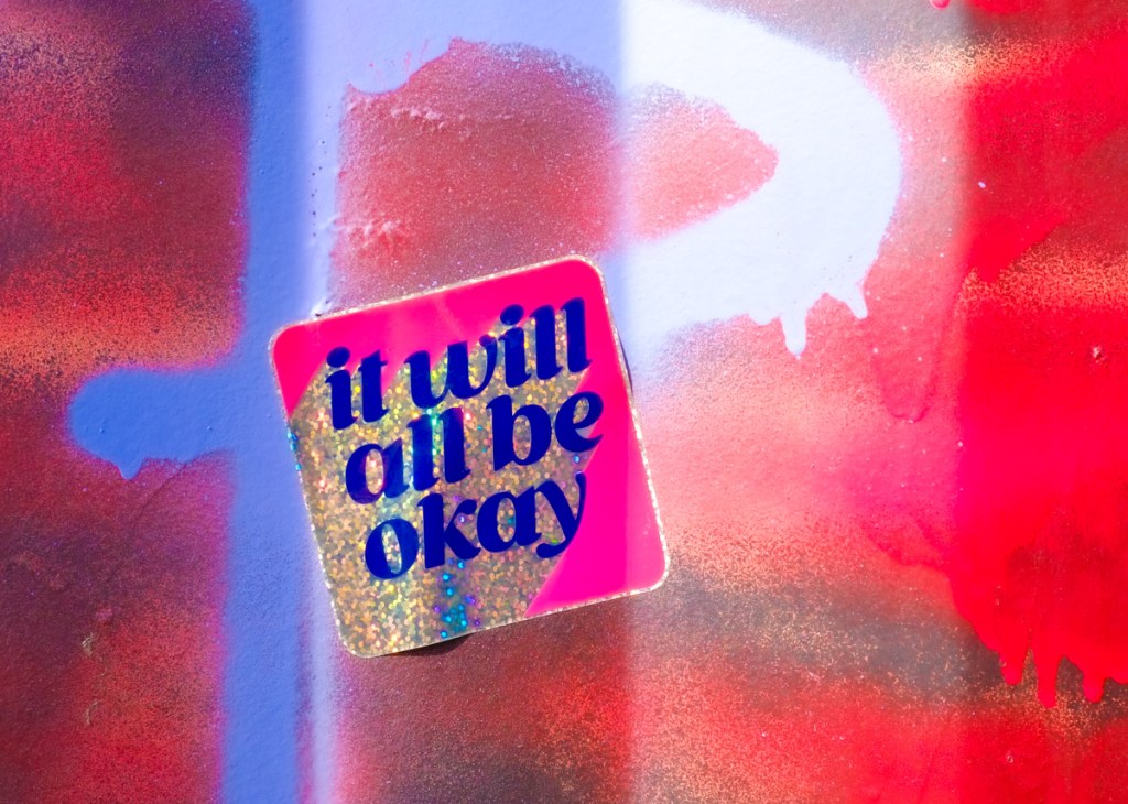 small sticker in pink and glittery gold that says it will all be okay