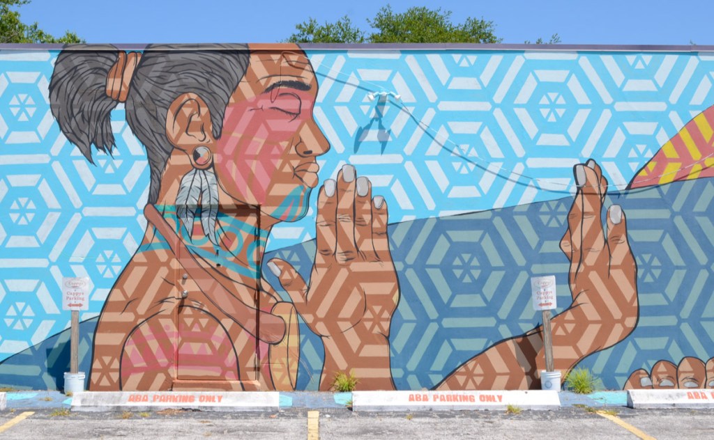 part of a mural by Daniel R. Barojas, a man in profile with feather earring,