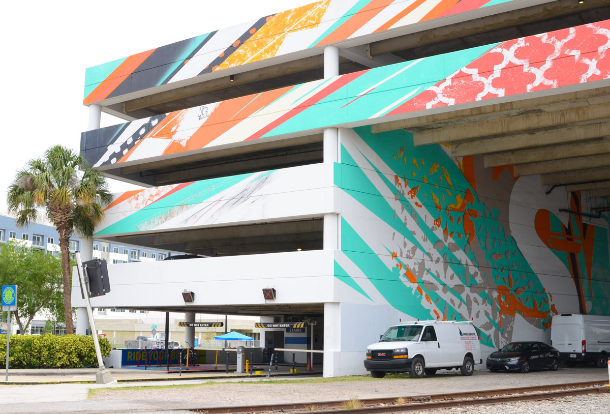 street art on a parking garage, with the words stay curious in large block letters