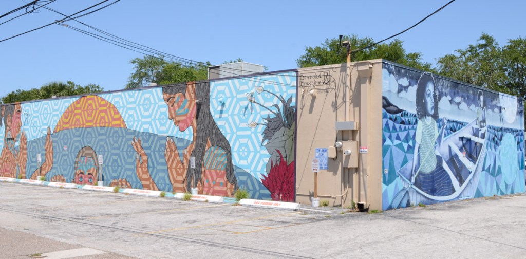 two murals on two sides of the same building, meet in the middle, part of shine festival st. petersburg murals