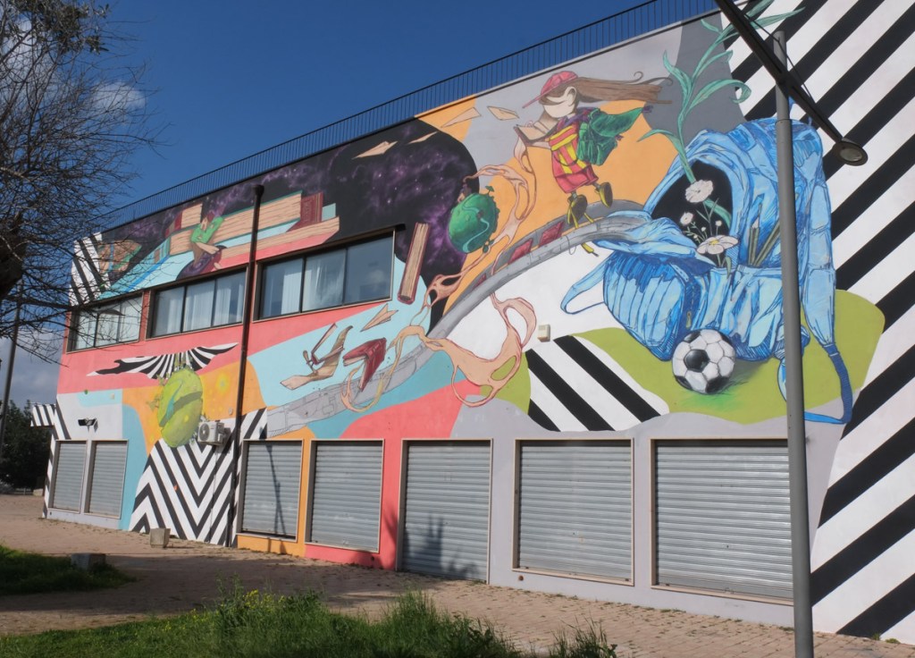 mural on a wall, collage of images, with lots of dominant diagonal stripes in black and white