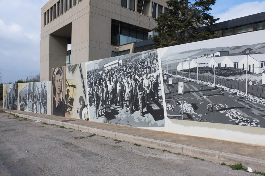 mural in shades of grey using images of old photographs from Camp 65 from WW2, a group of 6 images in a row