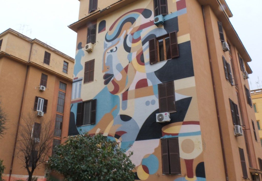large mural on the side of a four storey apartment building in Tor Marancia, Rome,